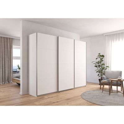 Großer weißer Schwebetürenschrank in einem hell eingerichteten Schlafzimmer mit Holzfußboden