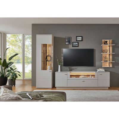 Wohnkombination mit beleuchtetem Hochschrank TV-Lowboard Fernseher und Wandregalen in einem hell eingerichteten Wohnzimmer