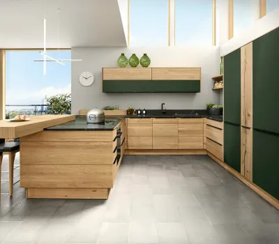 Frontalansicht der Decker Küche Bergamo aus massiver Eiche mit Fronten in Holz und Tannengrün.