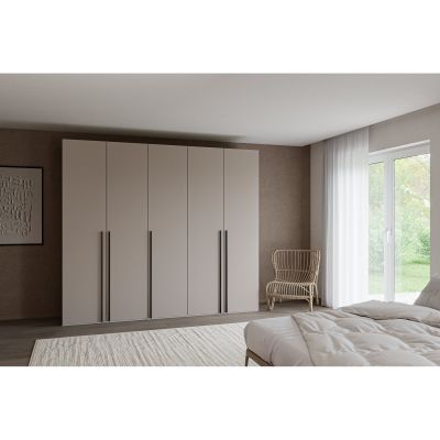 Fünftüriger Kleiderschrank mit geschlossenen Türen in einem Schlafzimmer neben einem Bett und einem Fenster