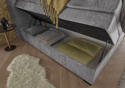 Boxspringbett „Vogue 15 grey“ in einem eingerichteten Schlafzimmer, Detailaufnahme des geöffneten Bettkastens, Stauraumfunktion erkennbar