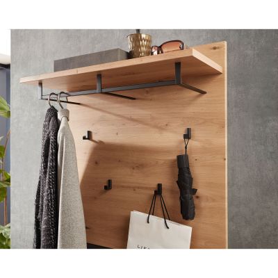 Nahaufnahme eines Wandpaneels in Holzoptik mit Ablage, Kleiderstange und Haken, an denen Kleidung und ein Regenschirm hängen.