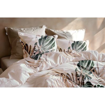 Bettwäsche Filippo in Natural, 135 x 200 cm: Nahansicht der bezogenen Bettdecke und Kissen auf einem Bett mit großen tropischen Blättern in Grün- und Beigetönen.