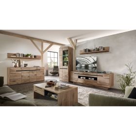 Ein kompletter Wohnraum mit Sideboard links, Vitrine, TV-Lowboard, Wandboard und Couchtisch. Auf allen Möbeln stehen Bücher und Dekorationen.
