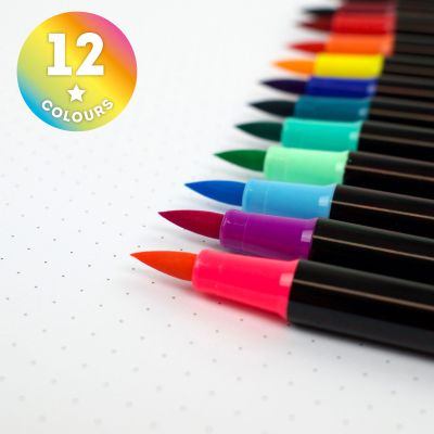 Zwölf Brushpens in kräftigen Farben, in Nahaufnahme mit den farbigen Pinselspitzen fächerförmig dargestellt.