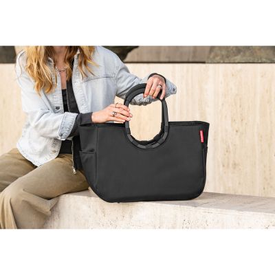 Shopper von Reisenthel, Modell Loopshopper M, in Schwarz mit schwarzen Rahmendetails, von einer Person an einem Ringgriff getragen.