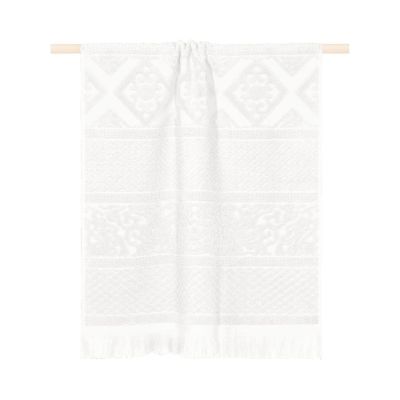 Weißes Duschtuch Harlem, 70 × 140 cm, mit eingewebten geometrischen Bordüren und Fransen, über einer Holzstange hängend.
