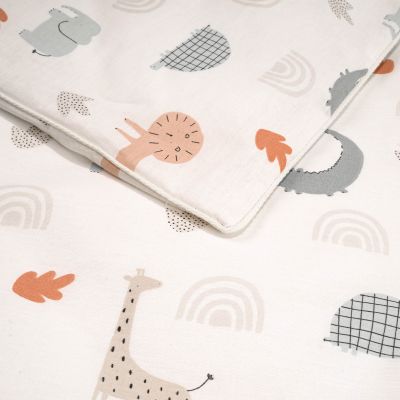 Nahaufnahme des Stoffes der Kinderbettwäsche mit Motiven wie Löwe, Giraffe und Regenbogen