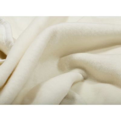 Nahaufnahme der Wohndecke CottonSense natur mit weichen cremefarbenen Stofffalten und flauschiger Oberfläche.