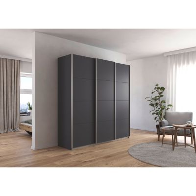 Moderner grau-metallicer Kleiderschrank mit Schiebetüren in einem hell eingerichteten Schlafzimmer mit Holzfußboden und Pflanze