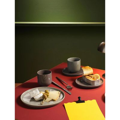 Arrangierte Szene: Dessertteller der Serie Coppa, Farbe Grün zusammen mit weiterem Geschirr auf einer gedeckten Fläche.