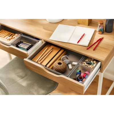 Graue Schubladenbox mit Büroartikeln in einer geöffneten Schreibtischschublade