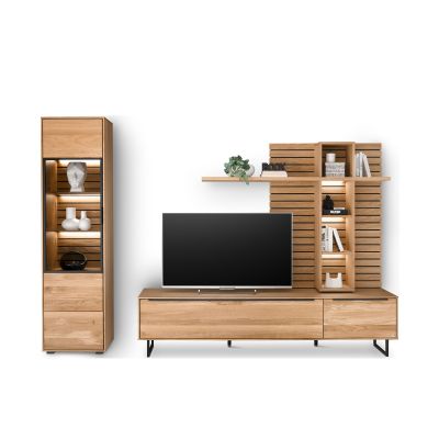 Frontansicht der Wohnkombination Musterring Set One Jackson in Eiche mit Vitrine, Lowboard und Wandpaneel. Mehrere offene Fächer sind durch eingeschaltete LED-Beleuchtung hervorgehoben.
