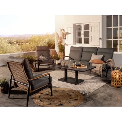Ein Sofa und mehrere Sessel mit grauen Polstern stehen um einen rechteckigen Tisch auf einer überdachten Terrasse mit Ausblick in die Landschaft.