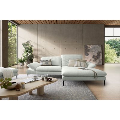 Helle Polstergarnitur mit Ottomane und Rückenkissen in einem modern eingerichteten Wohnzimmer mit großen Fenstern