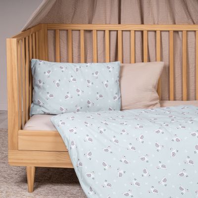 Kinderbett mit Jersey-Bettwäsche in hellem Blau und Schneckenmotiv als Bezug auf Kissen und Decke