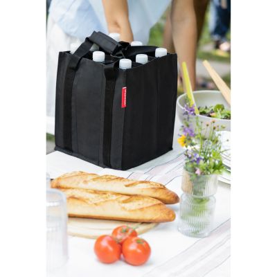Flaschentasche von Reisenthel, Modell Bottlebag, in Schwarz, mit Flaschen auf einem gedeckten Tisch im Freien.