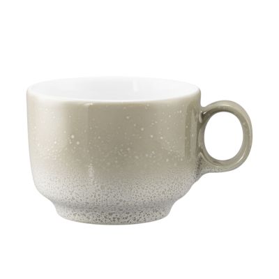 Seitenansicht: Tasse in Grau-Beige. Erkennbar: niedrige Form mit gesprenkeltem Verlauf und Henkel.