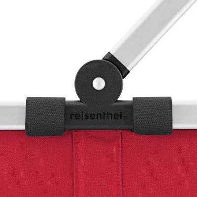 Einkaufskorb von Reisenthel, Modell Carrybag, in Rot, als Nahaufnahme des Gelenks zwischen Aluminiumgriff und Korbrand.