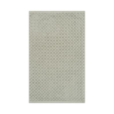 Gästetuch in der Farbe Seegras, flach auf weißem Hintergrund gezeigt; die fein geometrisch strukturierte Oberfläche ist über die gesamte Fläche sichtbar.