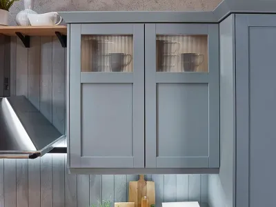 Wandschrank einer Landhausküche mit grauen Rahmenfronten und markanten Kranzleisten
