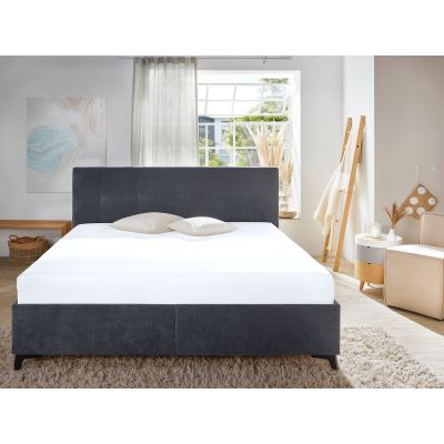 Spannbetttuch in Weiß auf einem Bett in einem hellen Schlafzimmer; weiße Bettwäsche und ein dunkles Kopfteil sind sichtbar; Größe 100 x 200 x 30 cm.