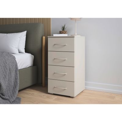 Beige Kommode mit vier Schubladen neben Bett im Schlafzimmer dekoriert mit Lampe Pflanze und Büchern
