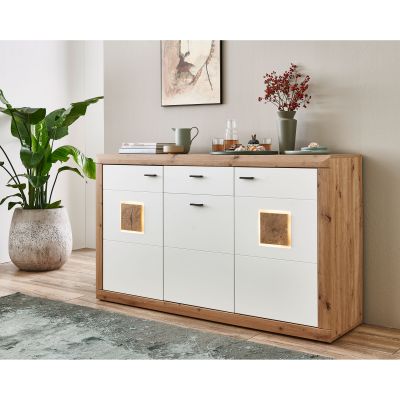 Sideboard mit weißen Fronten offenen Fächern und Holzoptik neben Zimmerpflanzen in einem hellen Wohnraum
