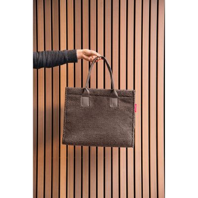 Shopper von Reisenthel, Modell Daily Shopper, in Schokoladenbraun aus Teddyfleece, von einer Person an den kurzen Griffen getragen
