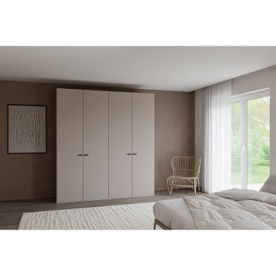 Kleiderschrank mit vier Drehtüren in einem Schlafzimmer neben einem Bett