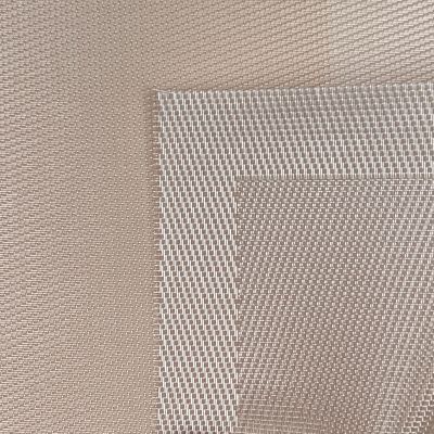 Nahaufnahme der fein gewebten Oberfläche und der eingefassten Kante des Tischsets in Beige