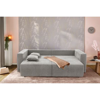 Graues Schlafsofa mit ausgeklappter Liegefläche und Decke in wohnlicher Schlafzimmeroptik