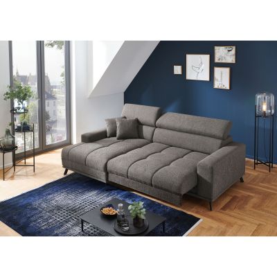 Dunkelgraue Wohnlandschaft mit Longchair links im Bild, ausgezogenen Sitzflächen und aufgestellten Kopfstützen in einem hellen Wohnzimmer