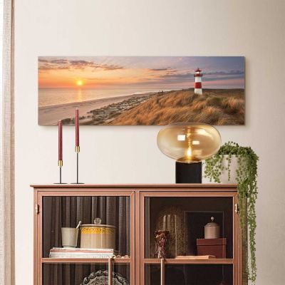 Das Wandbild „Lighthouse Sunset“ in Beige, 30 × 90 cm, hängt in einem eingerichteten Wohnraum und zeigt die Größenwirkung an der Wand.
