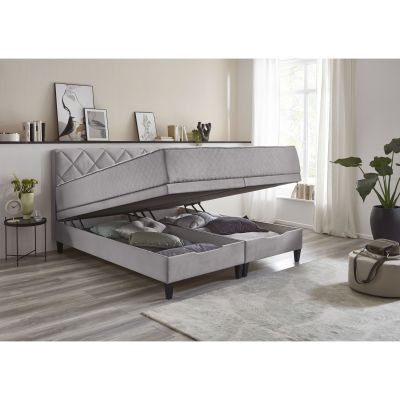 Boxspringbett mit hochgeklappter Liegefläche und sichtbarem Bettkasten zur Aufbewahrung