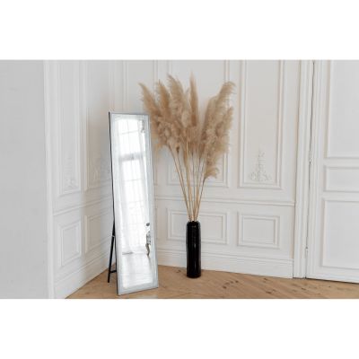 LED-Standspiegel Hermine mit Glitzereffekt, frei stehend in einem hell eingerichteten Raum; zu sehen ist die hohe LED-Spiegelfläche mit Standfuß und glitzernd wirkendem Rahmen; Maße ca. 40 x 160 x 4,5 cm.