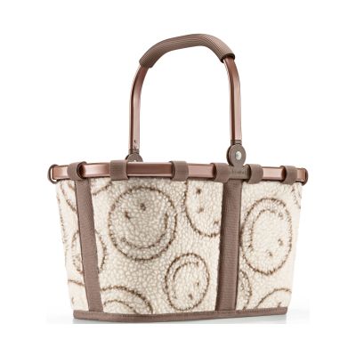 Kleiner Einkaufskorb von Reisenthel, Modell Carrybag XS, in Creme und Braun mit Smiley-Muster aus Teddyfleece, frontal mit hochgestelltem Tragegriff