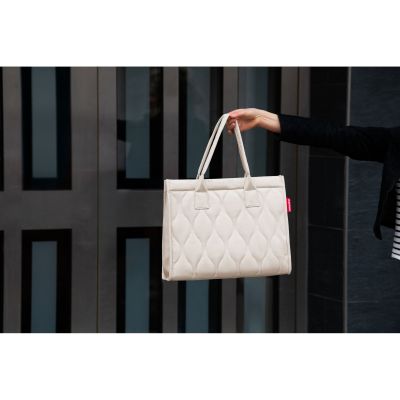 Shopper von Reisenthel, Modell Daily Shopper, in hellem Steinbeige mit Steppstruktur, von einer Person an den kurzen Griffen getragen