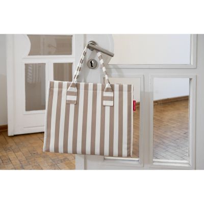 Beige-weißer Reisenthel Shopper mit Streifenmuster hängt an einem silbernen Türgriff in einem hellen Raum