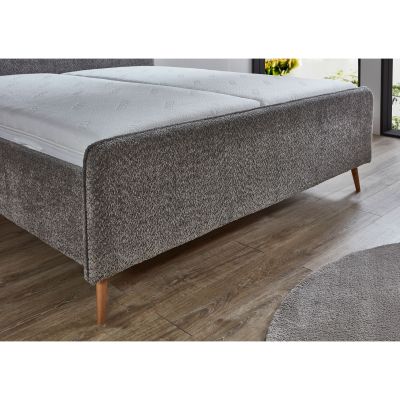 Polsterbett mit grauem Stoffbezug und Holzfüßen mit eingelegter Matratze im Schlafzimmer