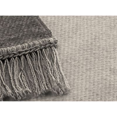 Nahaufnahme des Sofaschoners S&P silber mit grauem Gewebe, dunklerem Rand und langen Fransen.
