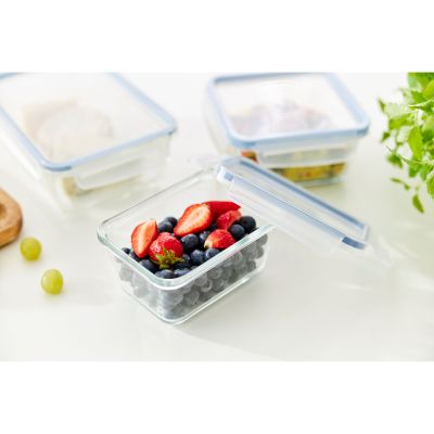 Transparente Frischhaltedose mit Beeren und geöffnetem Deckel auf einer Arbeitsfläche