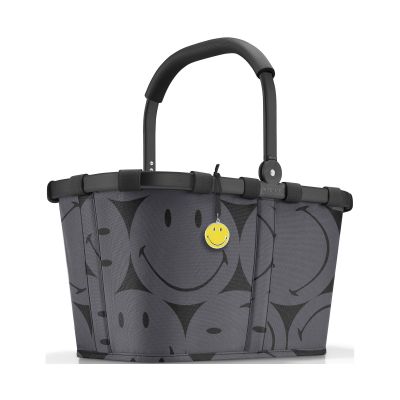 Einkaufskorb von Reisenthel, Modell Carrybag, in Grau mit großflächigem Smiley-Muster, frontal mit hochgestelltem Griff und gelbem Smiley-Anhänger.