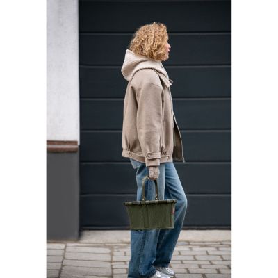 Kleiner Einkaufskorb von Reisenthel, Modell Carrybag XS, in Dunkelgrün aus geripptem Cord, von einer Person am Griff getragen.