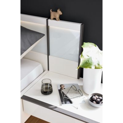 Bettkopfteil mit integrierter Ablagefläche und abgestellten Gegenständen im Schlafzimmer