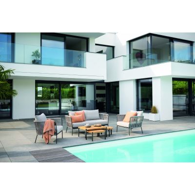 Gartensitzgruppe mit Tisch und Sitzmöbeln auf einer Terrasse vor einem modernen Wohnhaus mit Pool