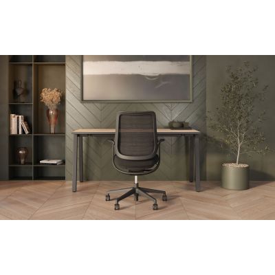 Schwarzer Drehstuhl Ovia von hinten vor einem Schreibtisch in einer eingerichteten Büroszene mit Regal und Pflanze.