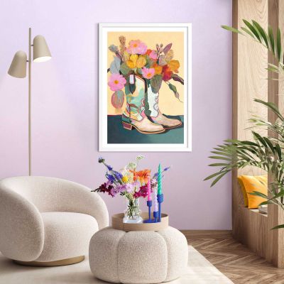 Das Wandbild „Flower Boots“ in Mehrfarbig, 50 × 70 cm, hängt in einem eingerichteten Wohnraum und zeigt die Größenwirkung an der Wand.