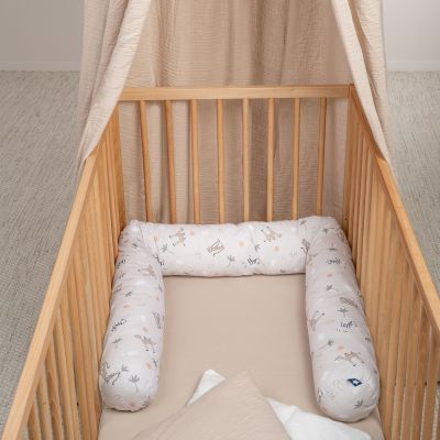 Bettschlange im hellbeigen Safari-Design ausgelegt im Kinderbett aus Holz