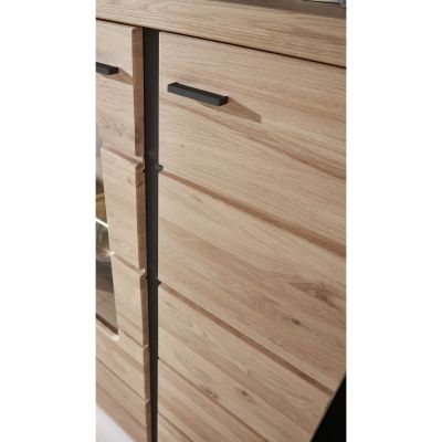 Nahaufnahme eines Sideboards in Holzoptik. Sichtbar sind die strukturierten Türfronten mit horizontalen Linien sowie dunkle, schmale Griffe.